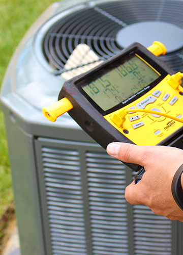 HVAC unit with person holding a pressure gauge.